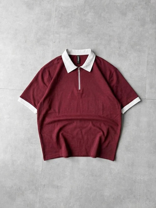 Maroon t-shirt with white collar and trim on a gray background