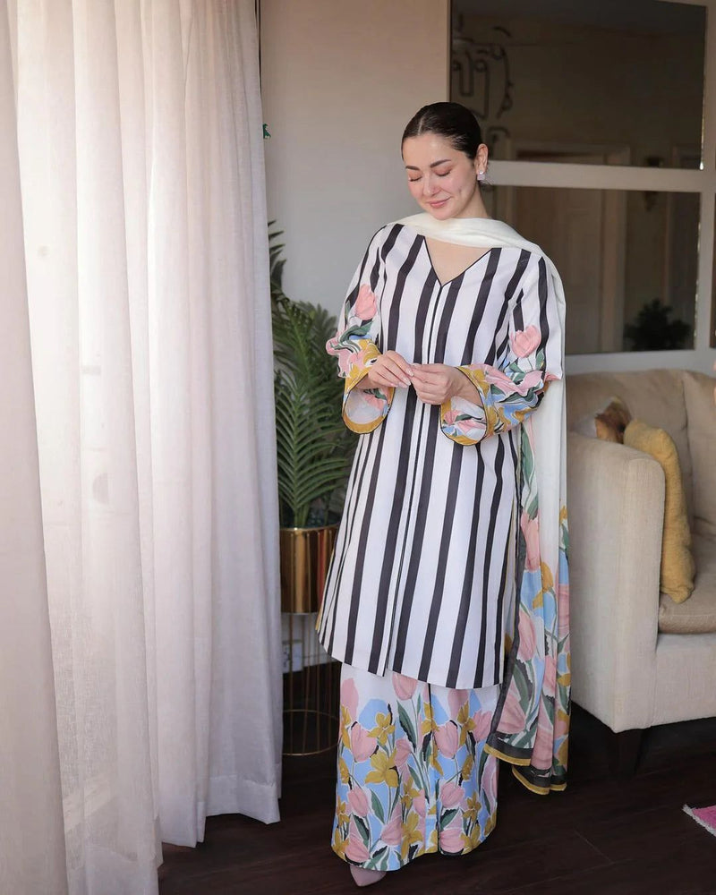 Woman wearing a black and white striped dress with floral patterns indoors.