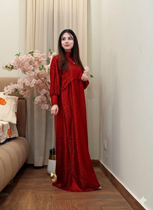 Woman in a red dress standing in a room with floral decorations.