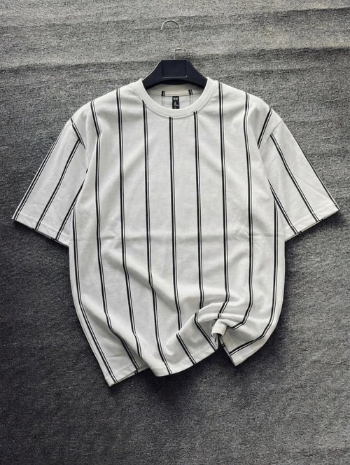 White t-shirt with black stripes on a gray textured surface