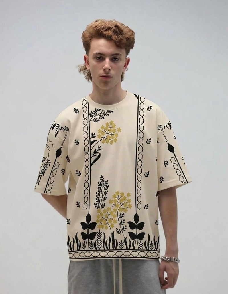 Person wearing a cream-colored shirt with black and yellow floral patterns on a plain background